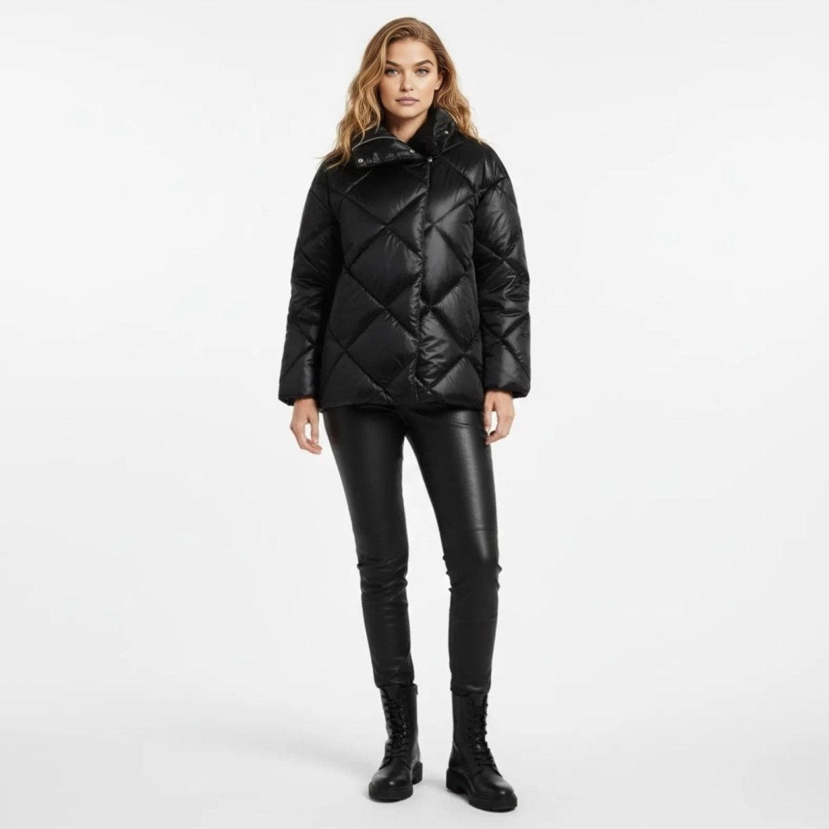 Model wearing the black diamond quilted high neck puffer jacket from Kouvr Fashion with black faux leather leggings and combat boots.