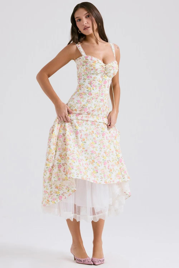 Model wearing Kouvr Fashion Eloise floral corset midi dress in white with pink and yellow flowers, showing the lace-up bustier and A-line skirt