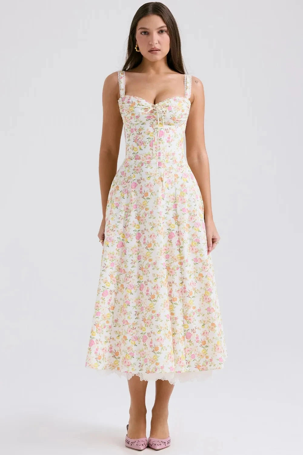 Model wearing Kouvr Fashion Eloise floral corset midi dress in white with pink and yellow flowers, showing the lace-up bustier and A-line skirt
