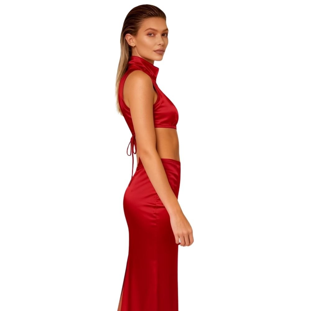 Woman wearing a red kouvr dress with cut-out design on a white background