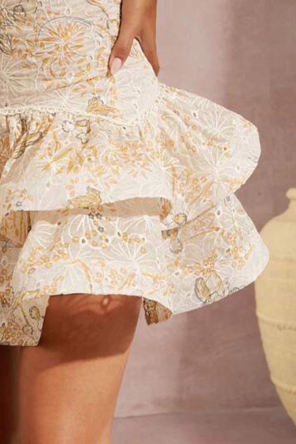 Model wearing Kouvr Fashion Faye beige embroidered halter mini dress with tiered ruffles