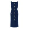 A woman wearing the Kouvr Fashion Fiorella blue sleeveless button-front midi dress in an elegant garden setting