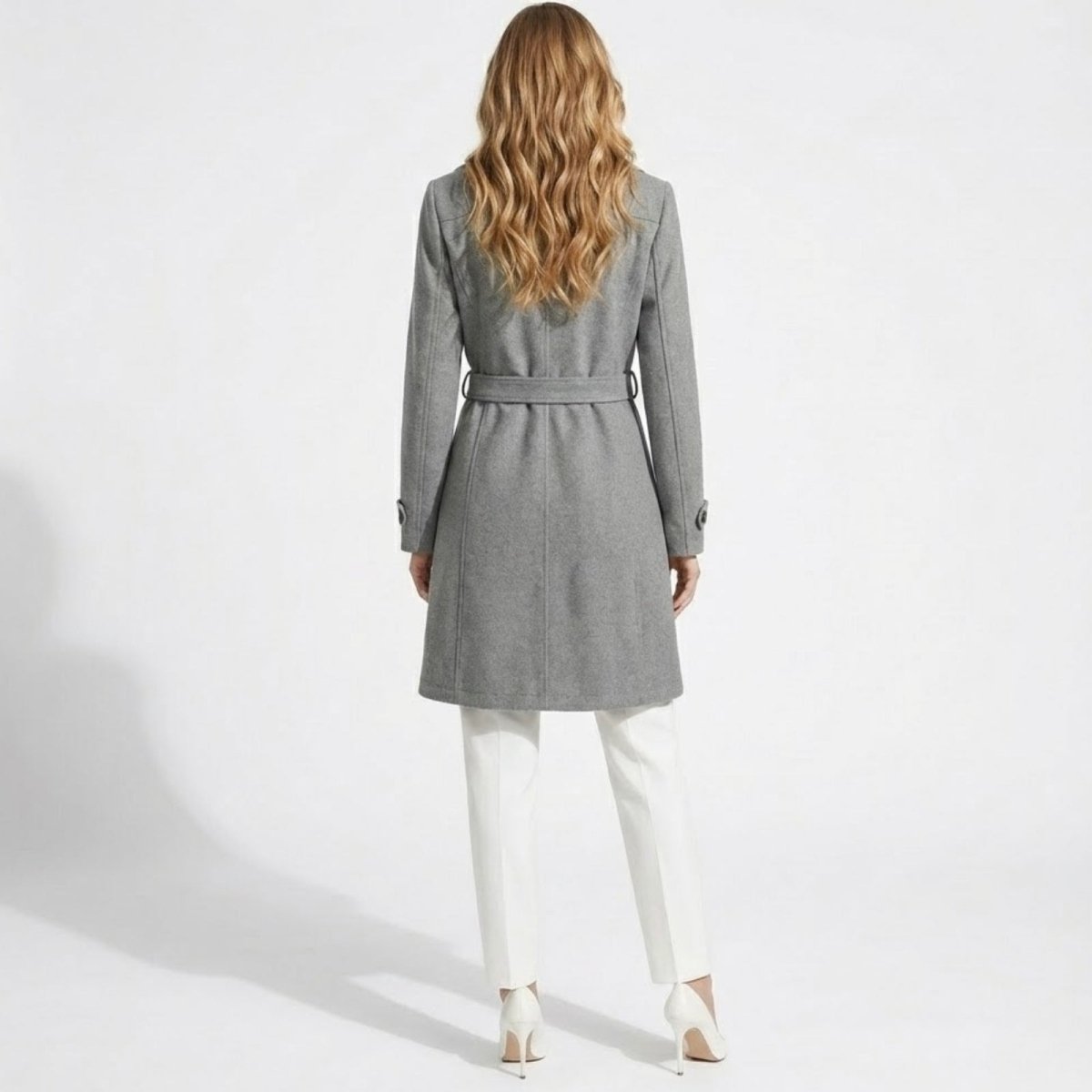 Back view of a woman wearing the Priscilla grey wool coat with the belt tied, showcasing the tailored fit and center seam detail.
