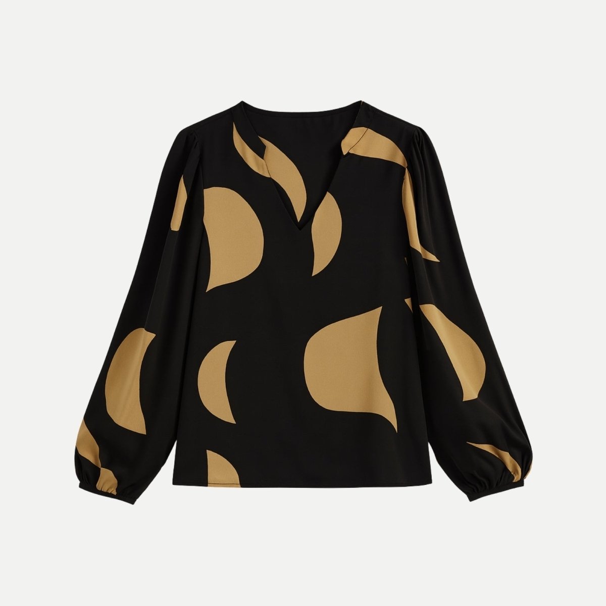 Flat lay of the Judith V-neck blouse, clearly displaying the abstract tan pattern on the black fabric and the shape of the bishop sleeves.