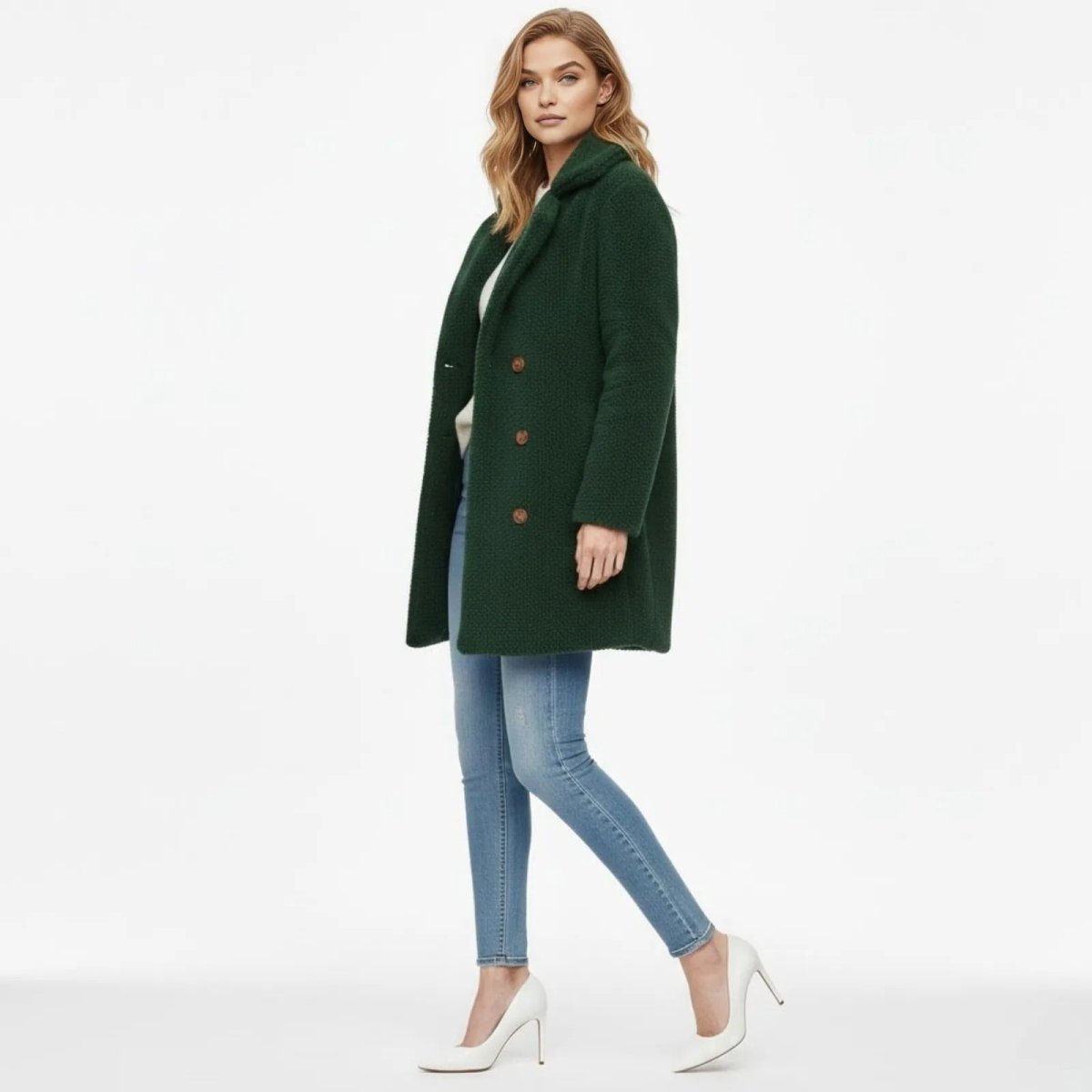 Side view of a woman walking in the green faux shearling Kianna coat, showcasing its mid-thigh length and elegant silhouette.