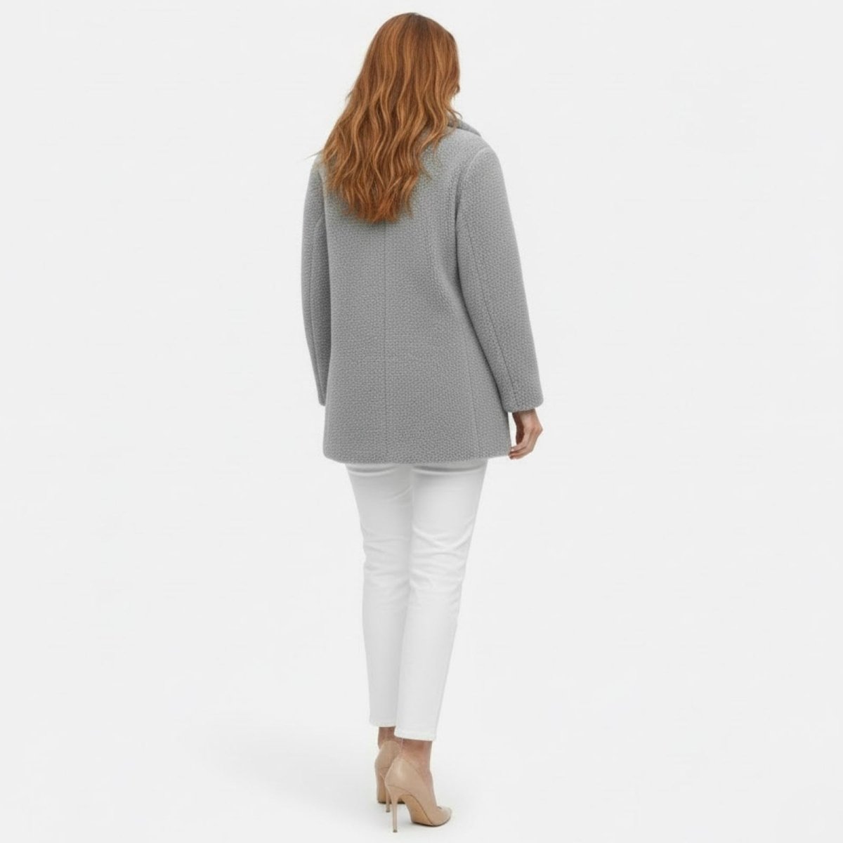 Back view of a model wearing the light grey faux shearling coat from Kouvr Fashion, highlighting the textured fabric and tailoring.