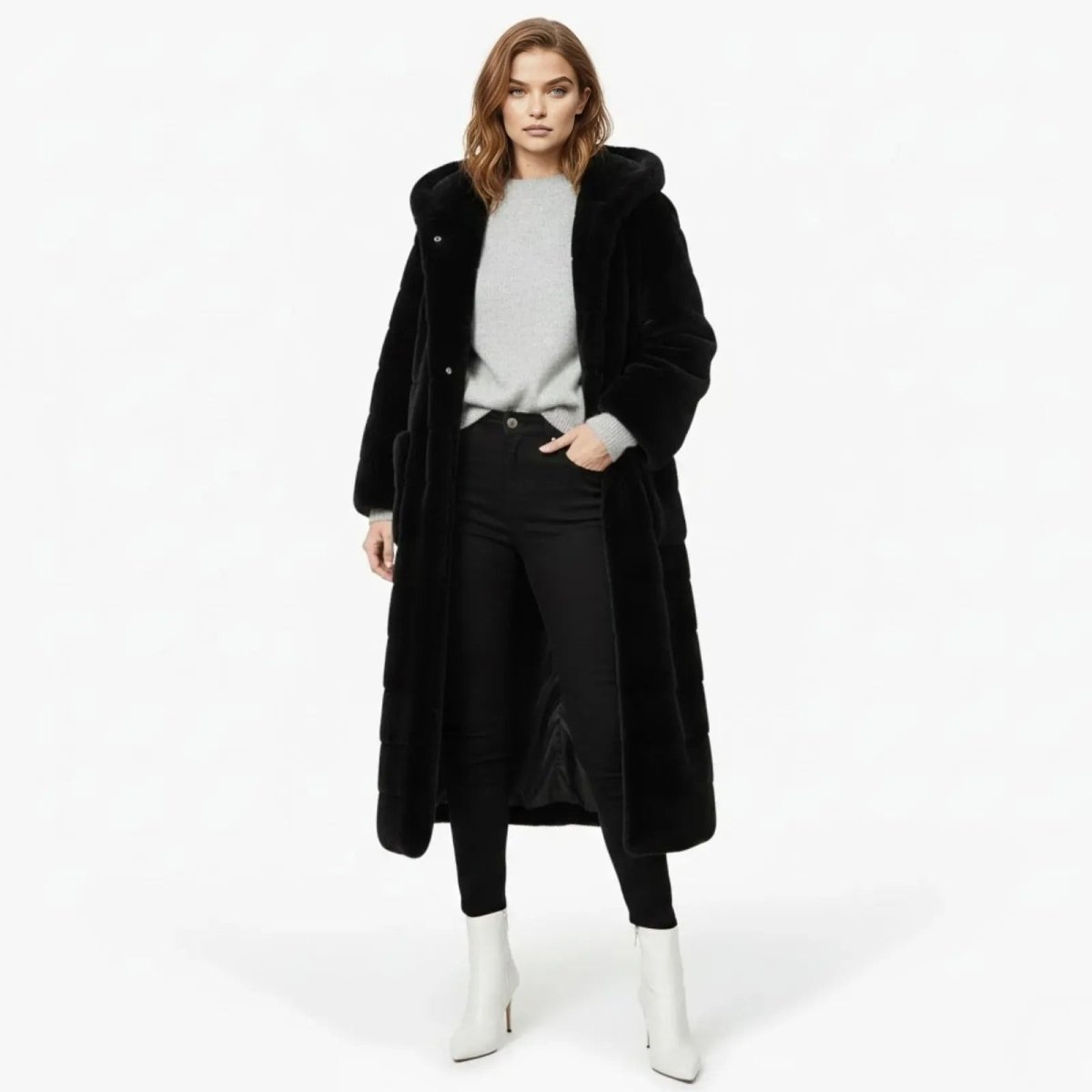 Model wearing the long black hooded faux fur maxi coat from Kouvr Fashion, standing forward with one hand in pocket.