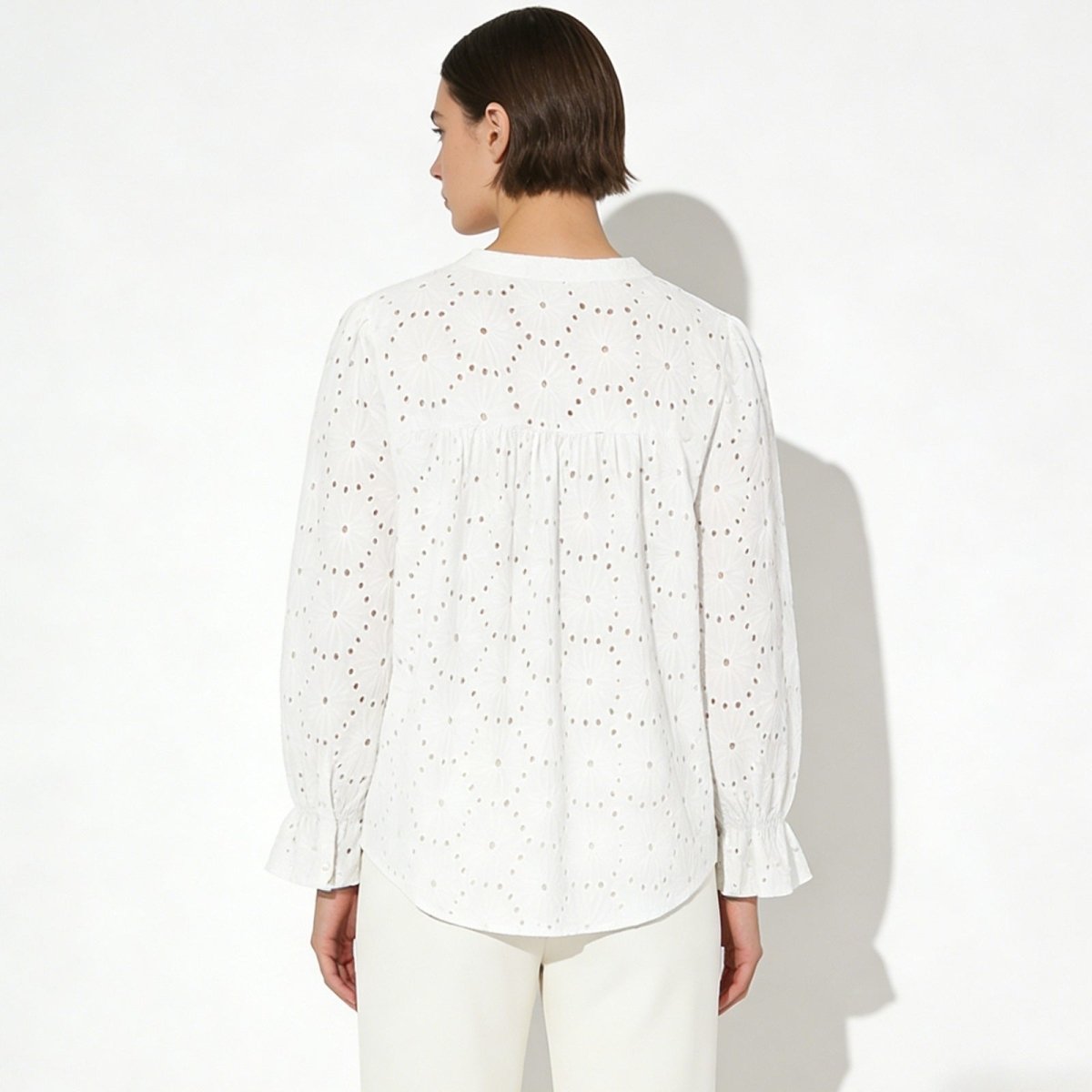 Back view of the Kouvr Fashion white cotton blouse, highlighting the gathered yoke and intricate lydia pattern.