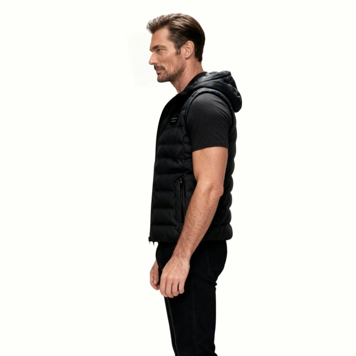Side profile of a man wearing the Kouvr Fashion black lightweight hooded gilet, showing its slim and athletic fit.