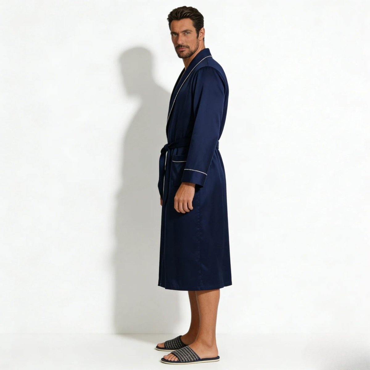Side profile of a man in a long sleeve navy silk dressing gown, highlighting the fit and length. Made by Kouvr Fashion.
