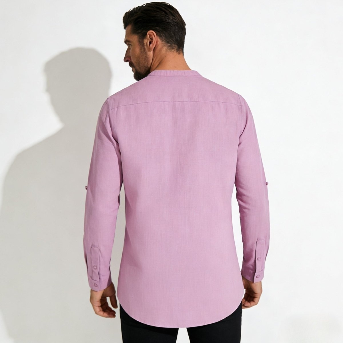 Back view of a male model in the Kouvr Fashion roby pink shirt, displaying the clean lines of the back yoke and the curved hem design.