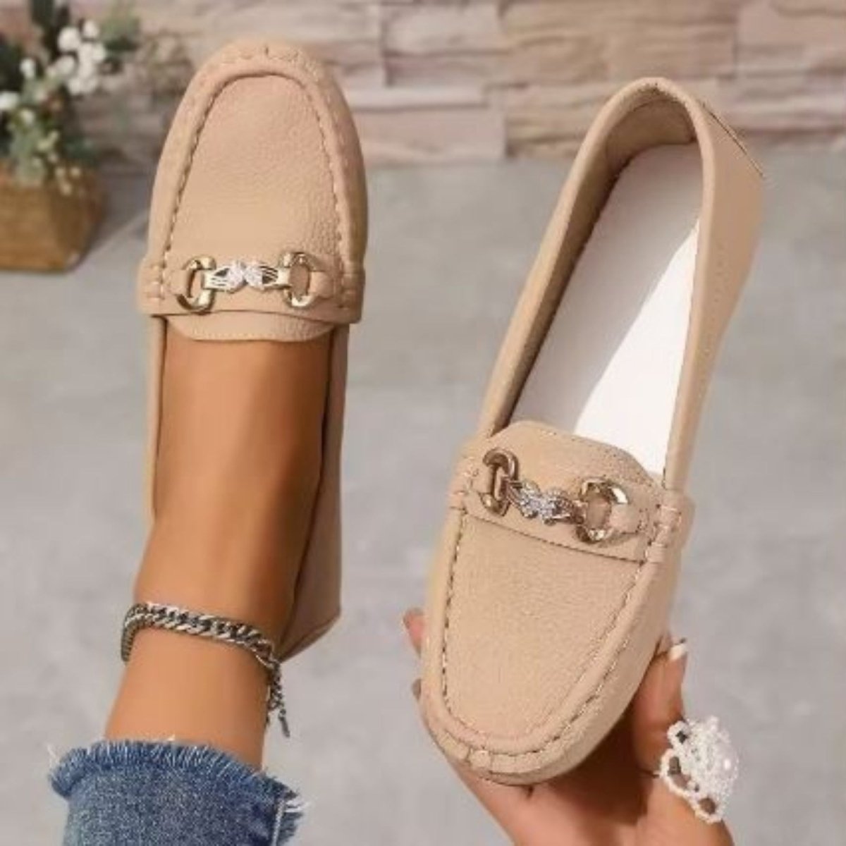 Close-up of a woman wearing Kouvr Mildred khaki leather loafers, paired with casual denim for an elegant look.