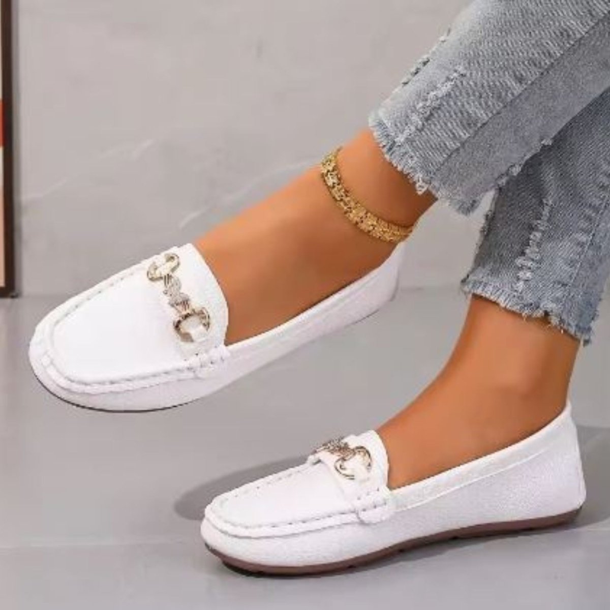 A model posing in Kouvr Mildred white leather loafers, showing their versatility for everyday chic style.