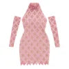 A woman wearing the Kouvr Fashion Myra Pink Sequin Halter Neck Bodycon Dress with matching long gloves, standing indoors
