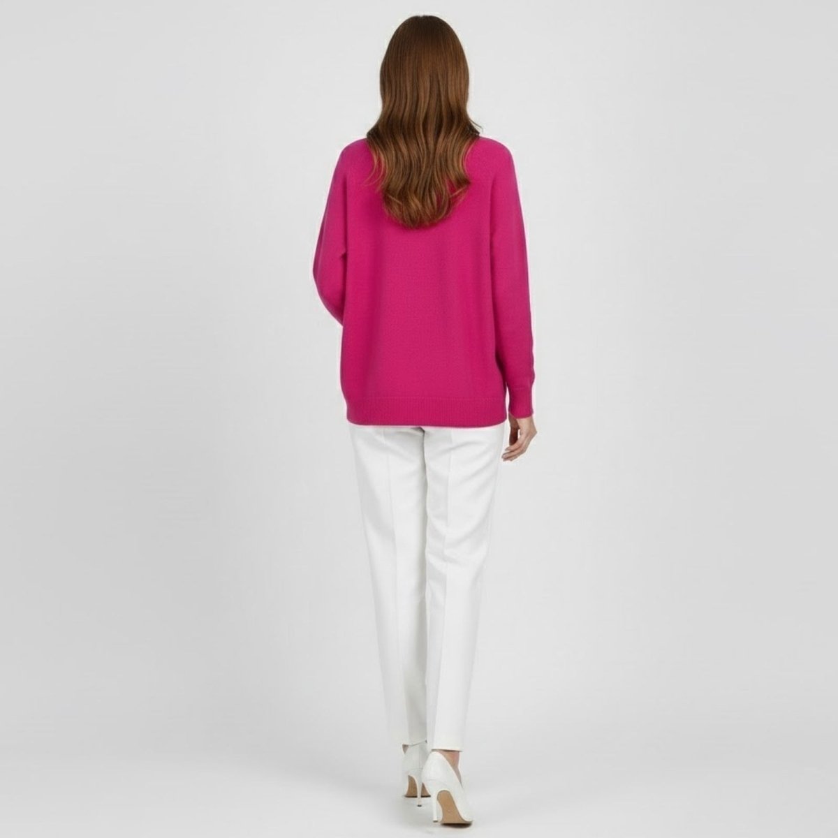Back view of a model wearing the Kouvr Fashion oversized crewneck sweater in vibrant fuschia pink, showing the full silhouette.