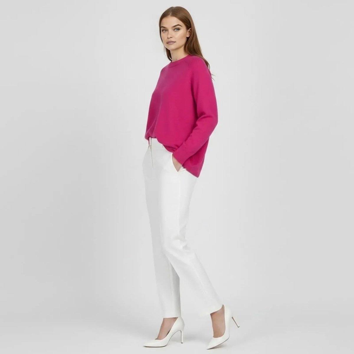 Side profile of a model in the Kouvr Fashion fuschia pink oversized cashmere blend sweater, showcasing its relaxed drape and fit.