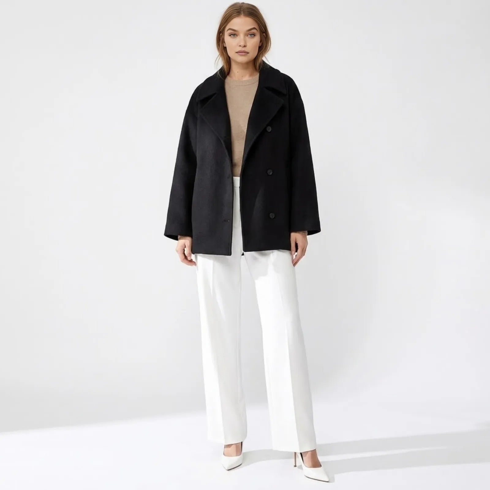Model wearing the Kouvr Fashion oversized double-breasted black wool peacoat with white wide-leg trousers and heels.
