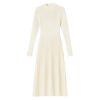 Model wearing the Kouvr Fashion long sleeve pleated knit maxi dress in cream, posing in a minimalist room