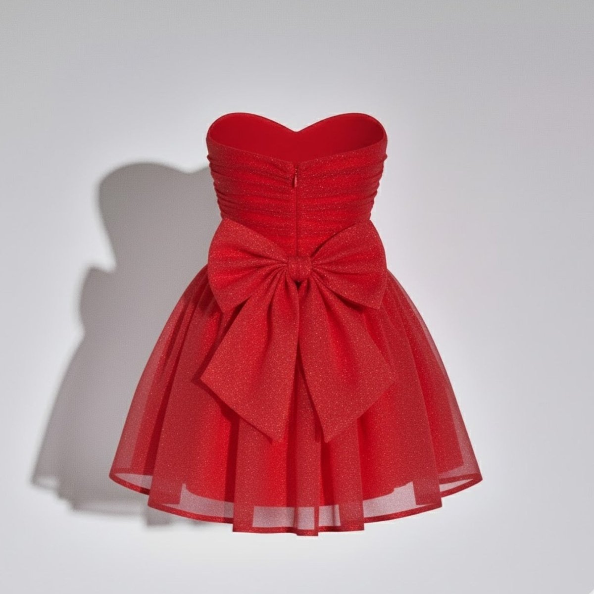 Product-only shot of the red strapless party dress, showing the texture of the ruched bodice and sparkling tulle skirt.