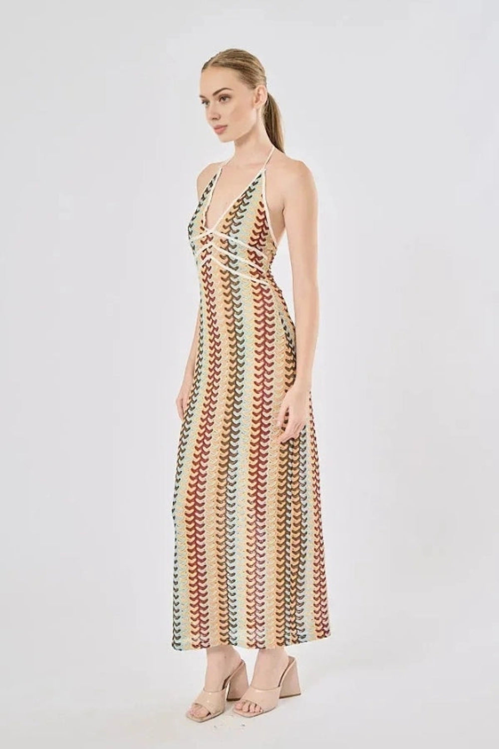 Model viewed from the back wearing the Kouvr Fashion 70s-inspired retro wave print halter maxi dress, showcasing the open-back design