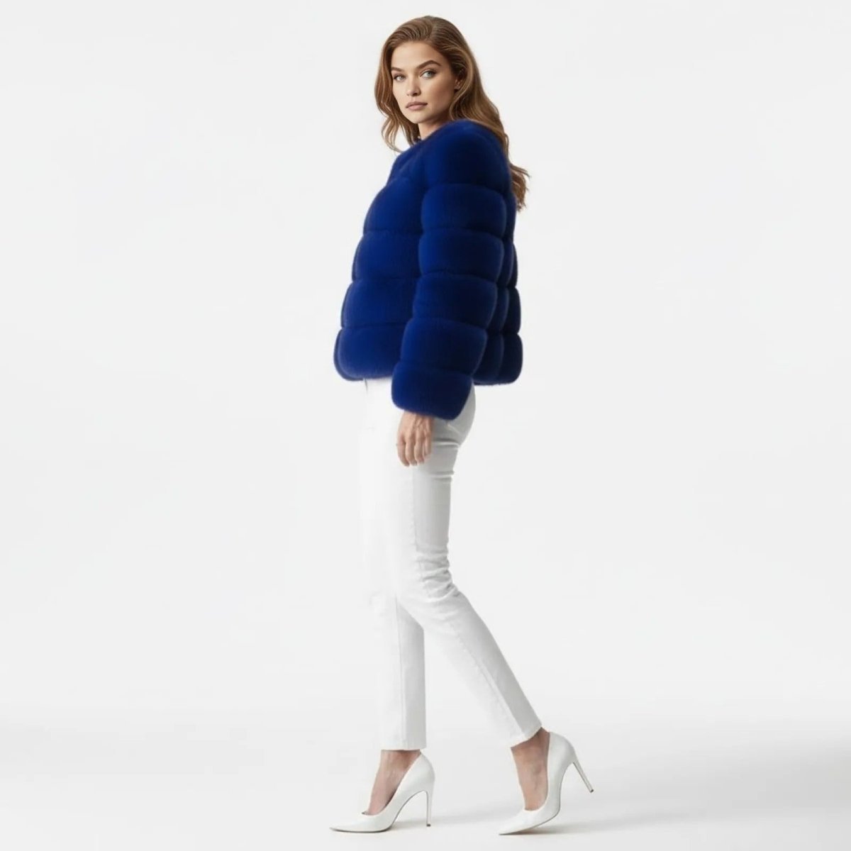 A female model in a side profile view walks while wearing the Kouvr Fashion cropped royal blue faux fur jacket. 