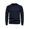Flatlay product shot of the Kouvr Fashion Deacon crewneck sweater in navy blue, showing the red embroidered logo and fabric texture.