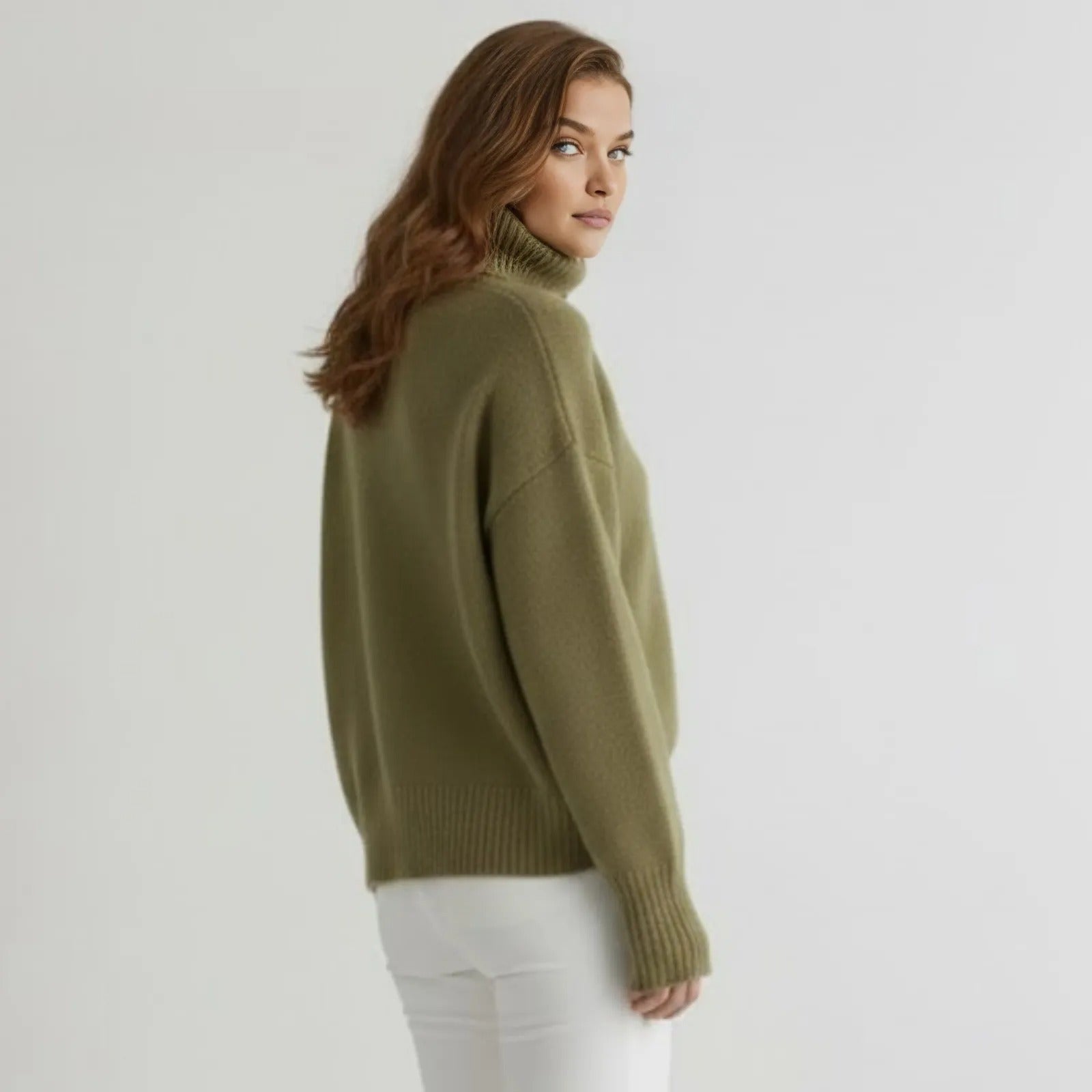 Back view of the Kouvr Fashion oversized cashmere turtleneck sweater in a rich khaki, highlighting its seamless construction.