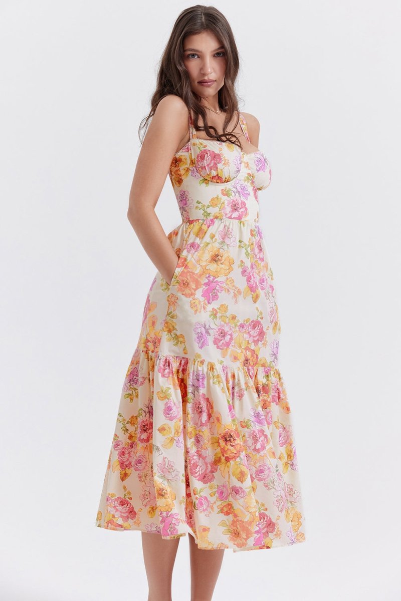 Side profile of a woman in The Persephone floral bustier midi dress, highlighting the A-line silhouette and tiered hem.