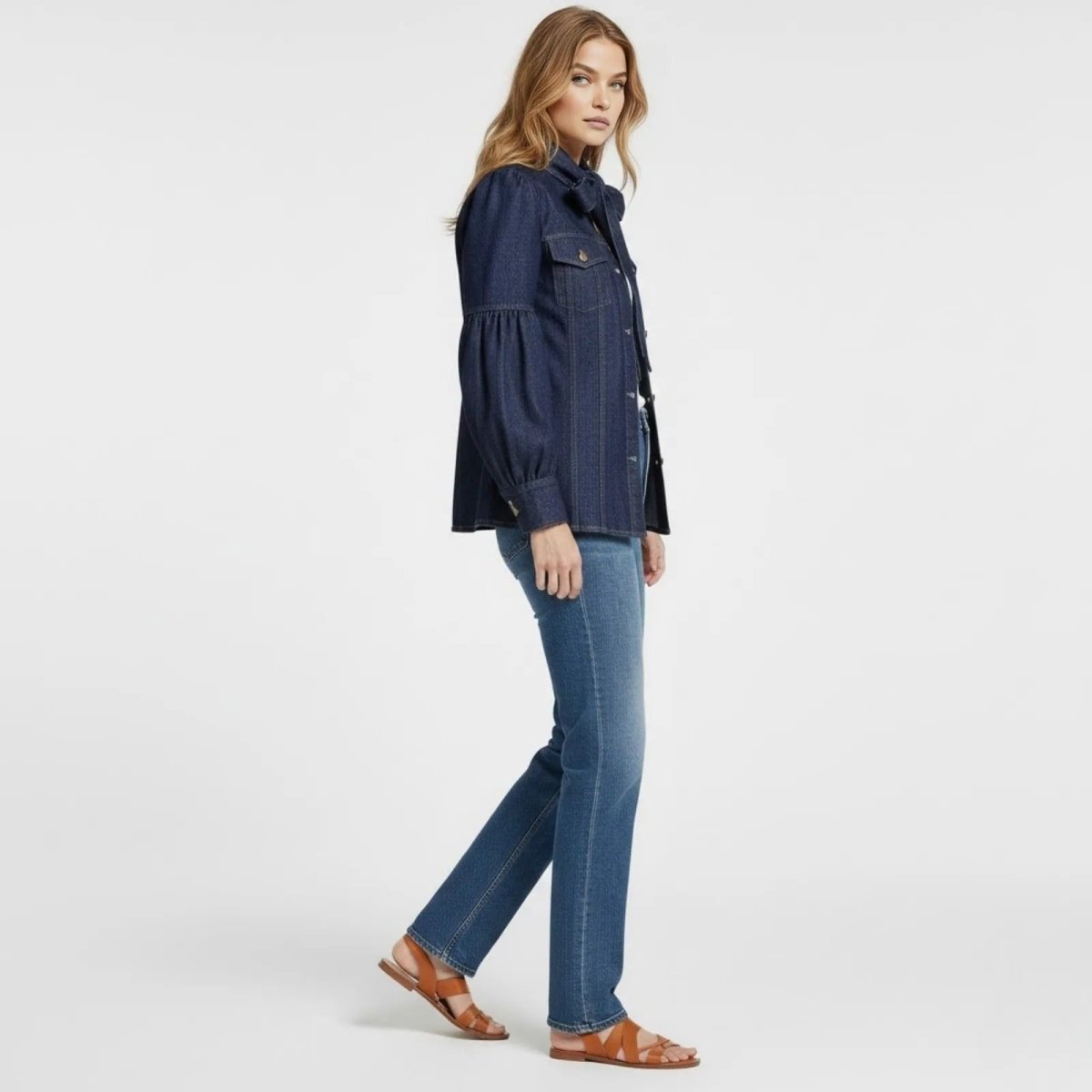 Side profile of a model walking in the Kouvr Fashion puff sleeve denim blouse, showcasing the voluminous sleeve shape and tailored fit.