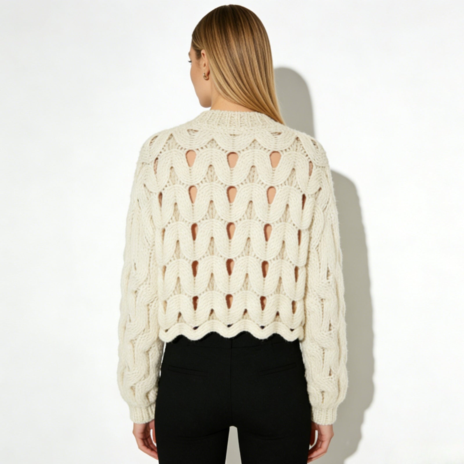 Back view of the Kouvr Fashion Vanice open-knit sweater showcasing the continuous wave cutout pattern.