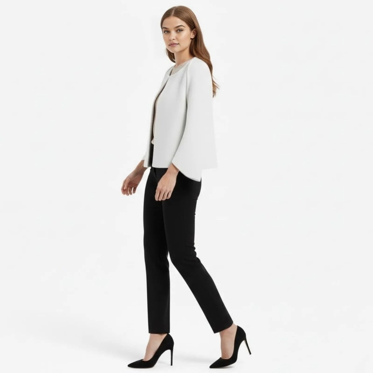 Side profile of a model walking in the Kouvr Fashion white bell sleeve jacket, showcasing the sleeve's architectural drape.