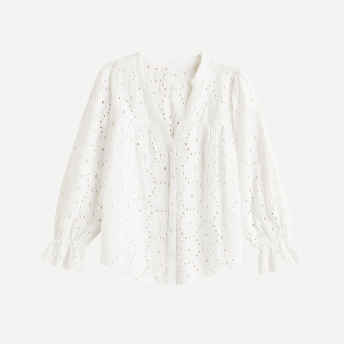 Flat lay of a white v-neck lydia blouse showing the button-front detail and long sleeves with ruffle cuffs.