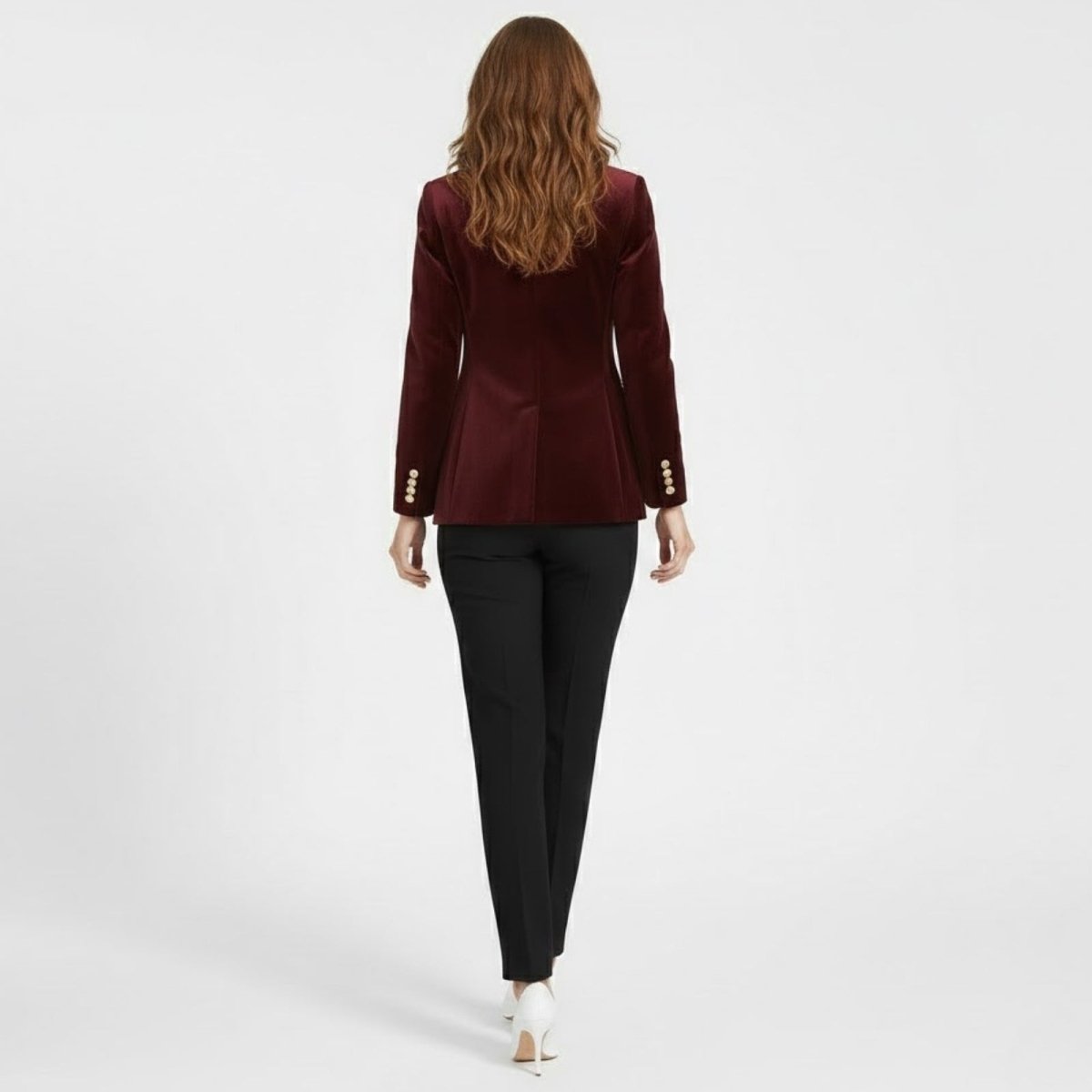 Back view of a model in the Kouvr Fashion burgundy velvet blazer, highlighting the single back vent and gold cuff buttons.