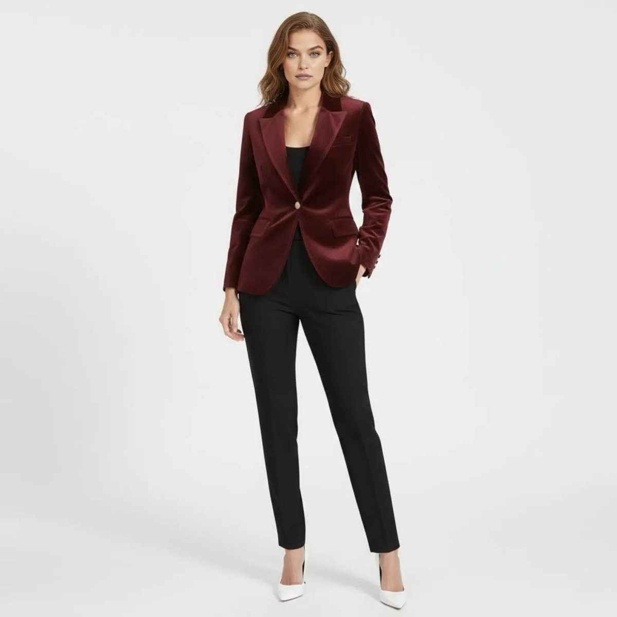 Model wearing the Kouvr Fashion single-breasted burgundy velvet blazer with a gold button, styled with black trousers and white heels, against a white background.