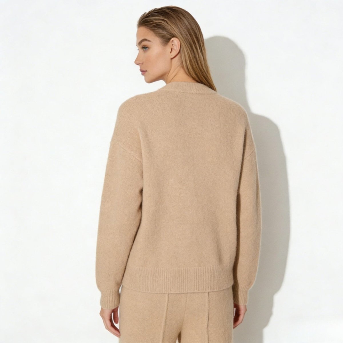 Back view of the Kouvr Fashion oversized cashmere cardigan in a neutral beige color, highlighting its clean and minimalist design.