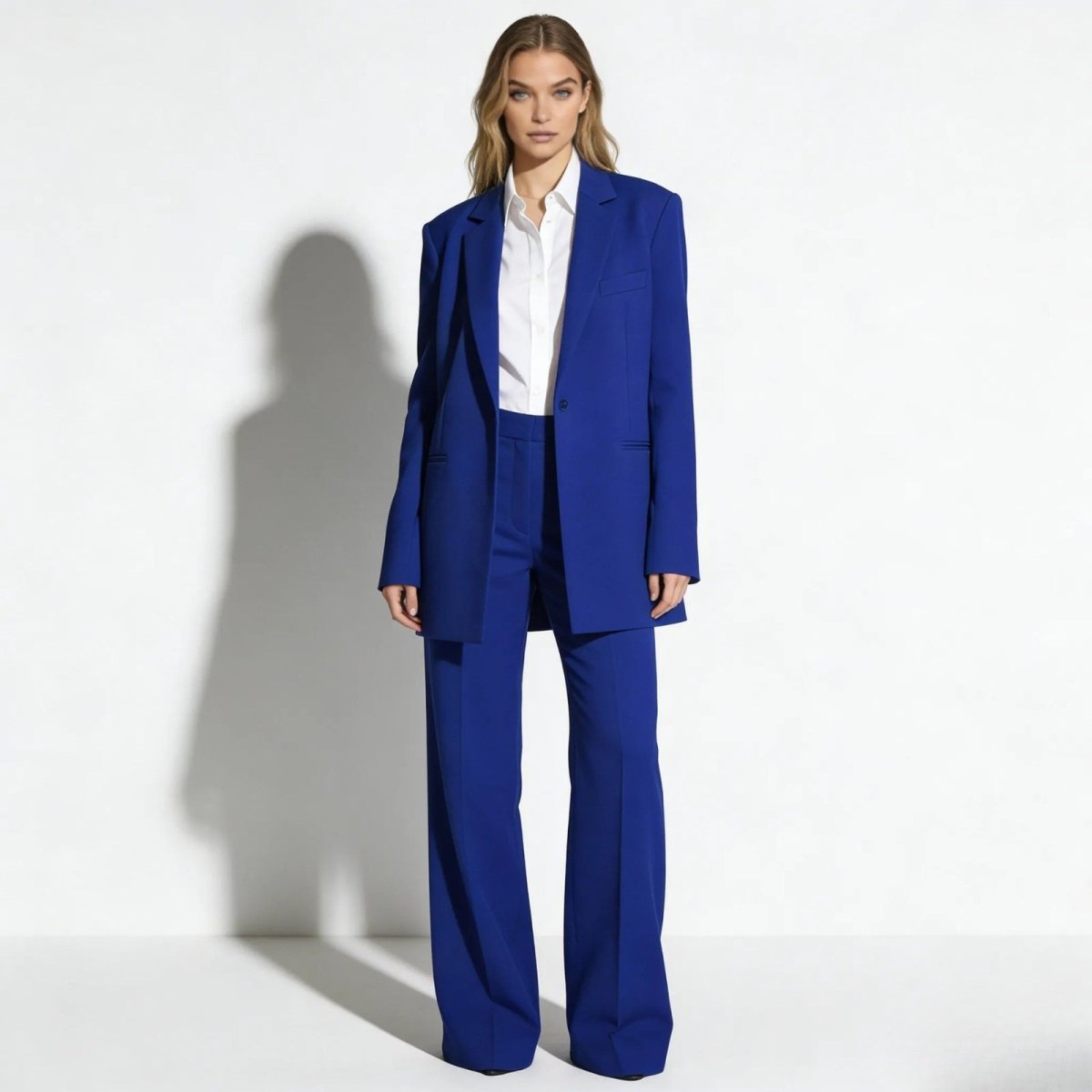 Model wearing the Kouvr Fashion royal blue oversized single-breasted blazer and matching wide-leg trousers with a white shirt, showing the full suit's powerful silhouette.