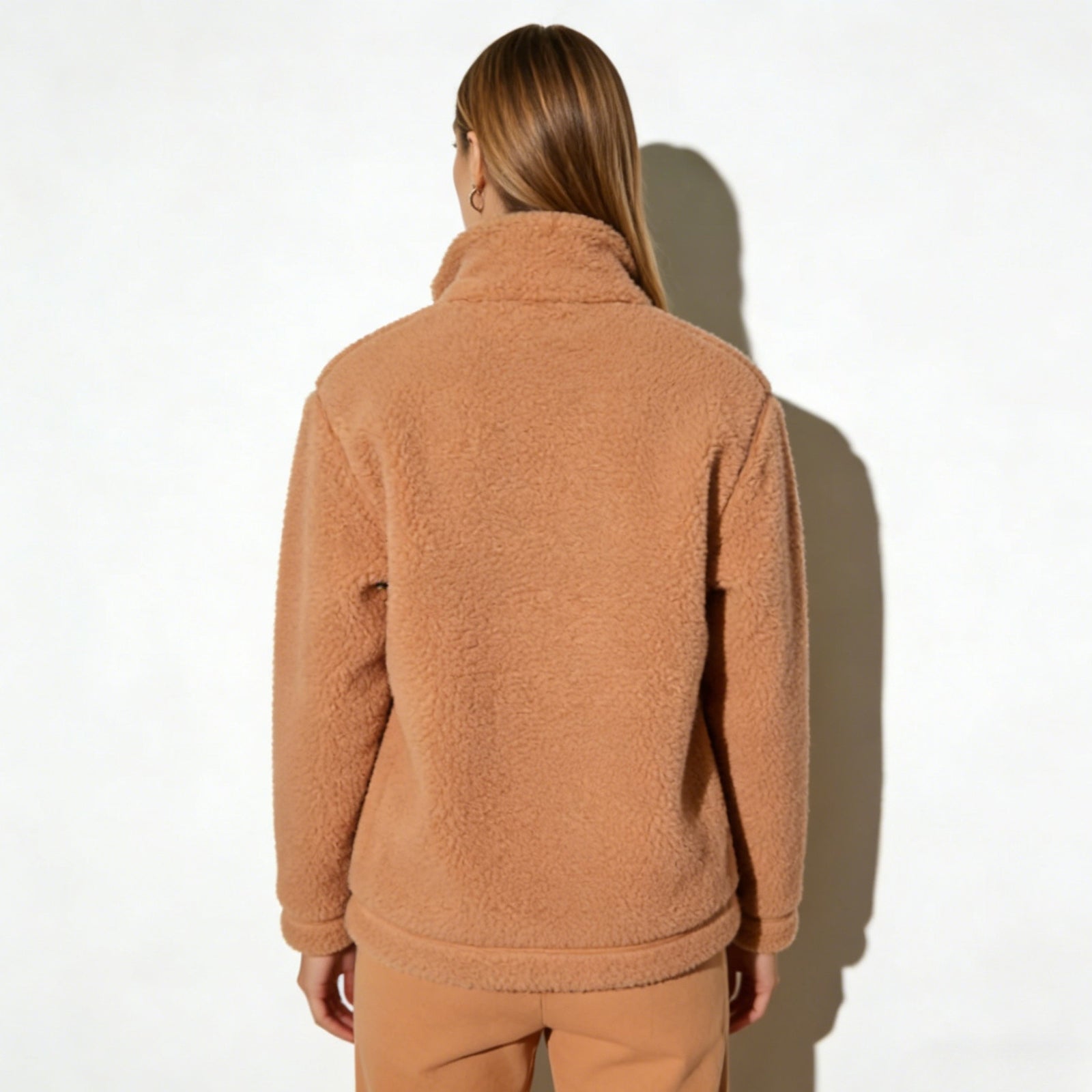Back view of the Kouvr Fashion women's tan sherpa jacket, showing the clean lines and structured back yoke detail.
