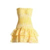 Model wearing Kouvr Fashion strapless yellow eyelet mini dress with tiered ruffle skirt