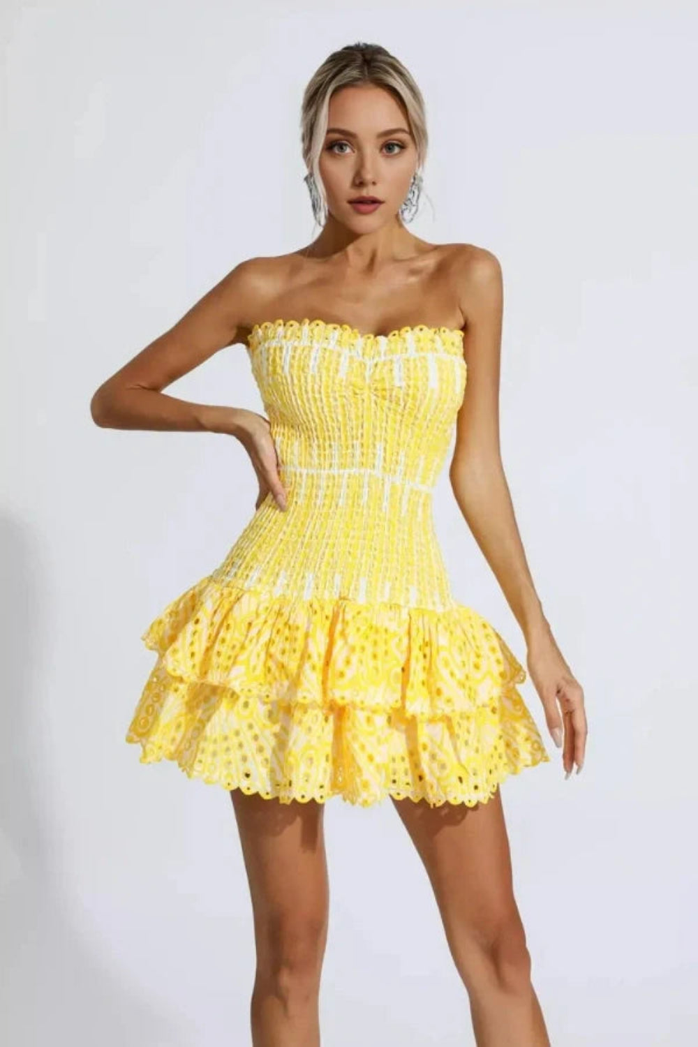 Model wearing Kouvr Fashion strapless yellow eyelet mini dress with tiered ruffle skirt