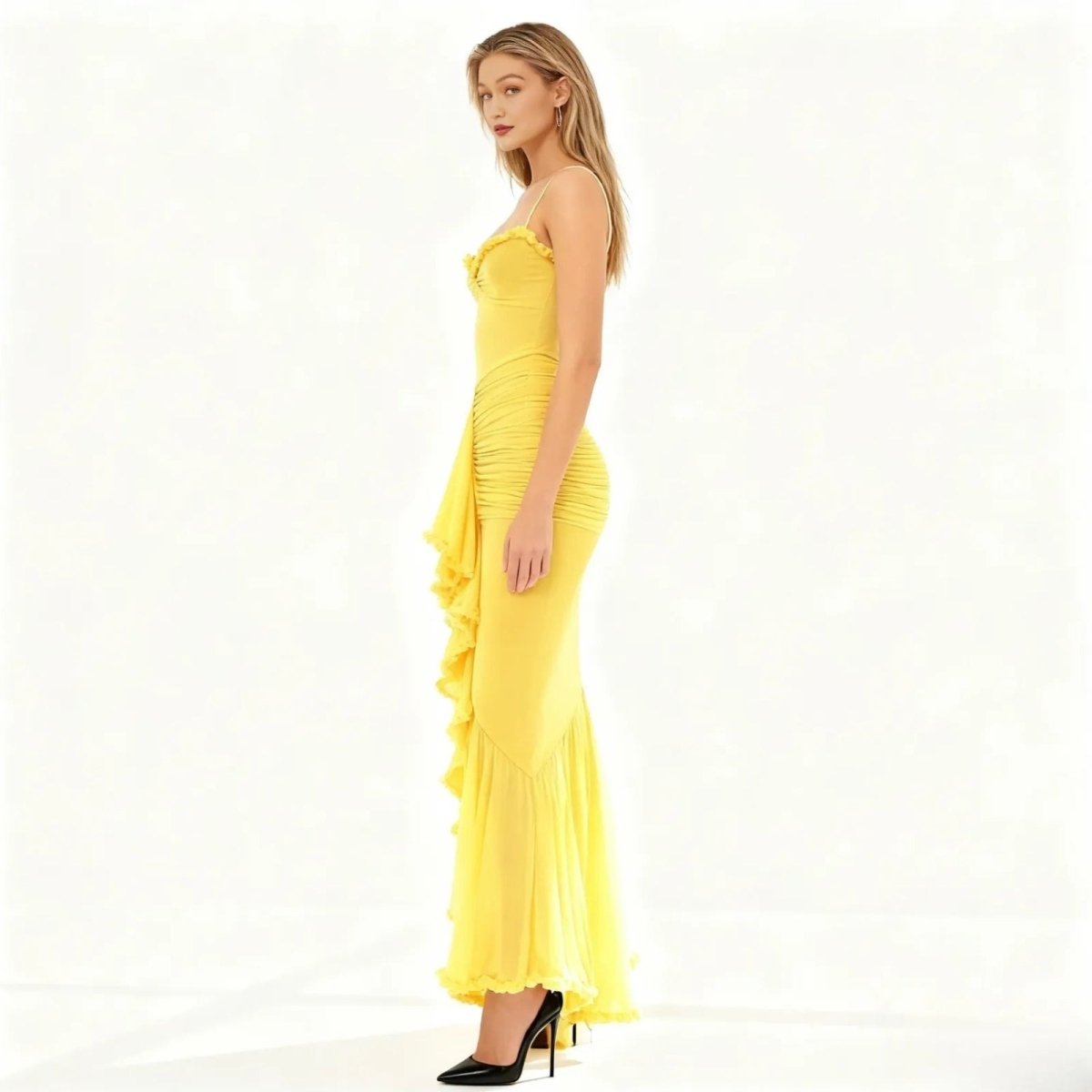Woman wearing a yellow kouvr  strapless dress with ruched details on a white background