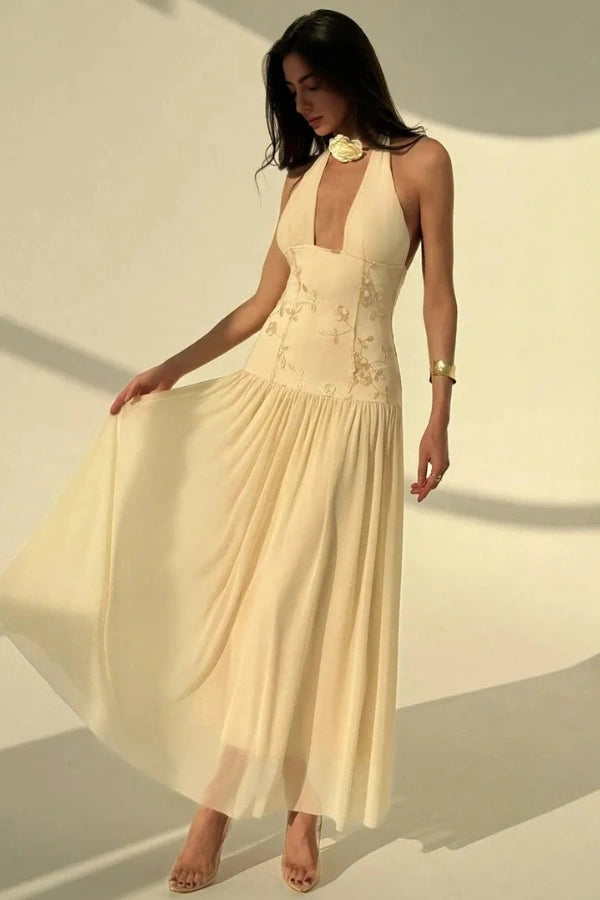 Model wearing the Kouvr Fashion Zoe yellow embroidered halter gown with open back