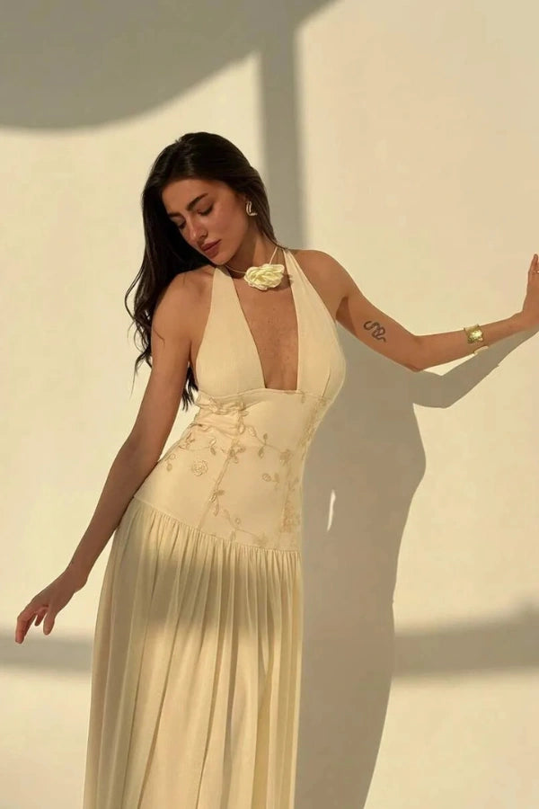 Model wearing the Kouvr Fashion Zoe yellow embroidered halter gown with open back