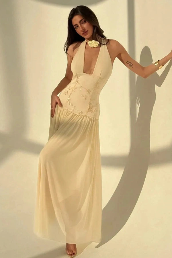 Model wearing the Kouvr Fashion Zoe yellow embroidered halter gown with open back