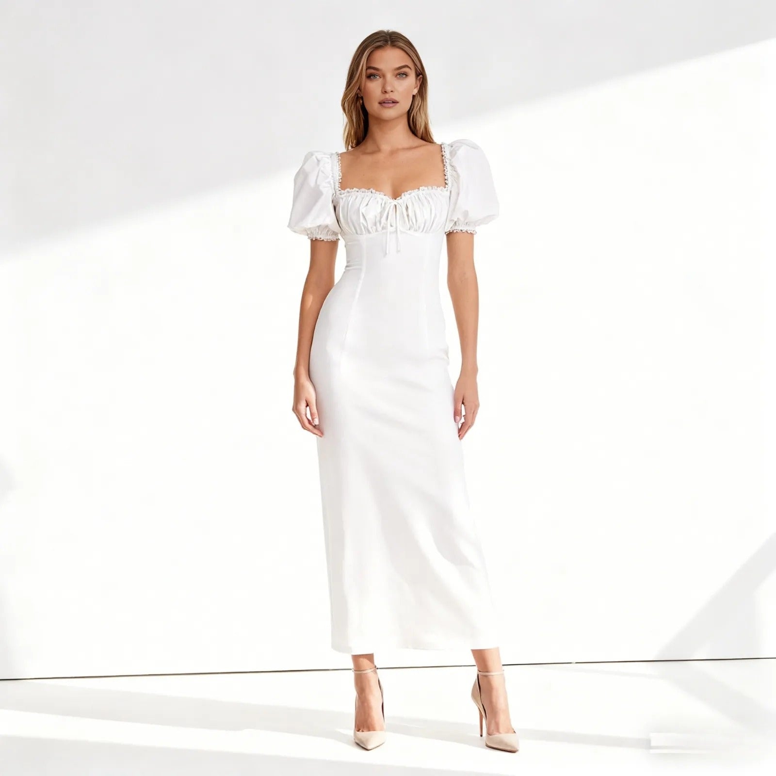 Woman wearing a white dress with puff sleeves on a white background