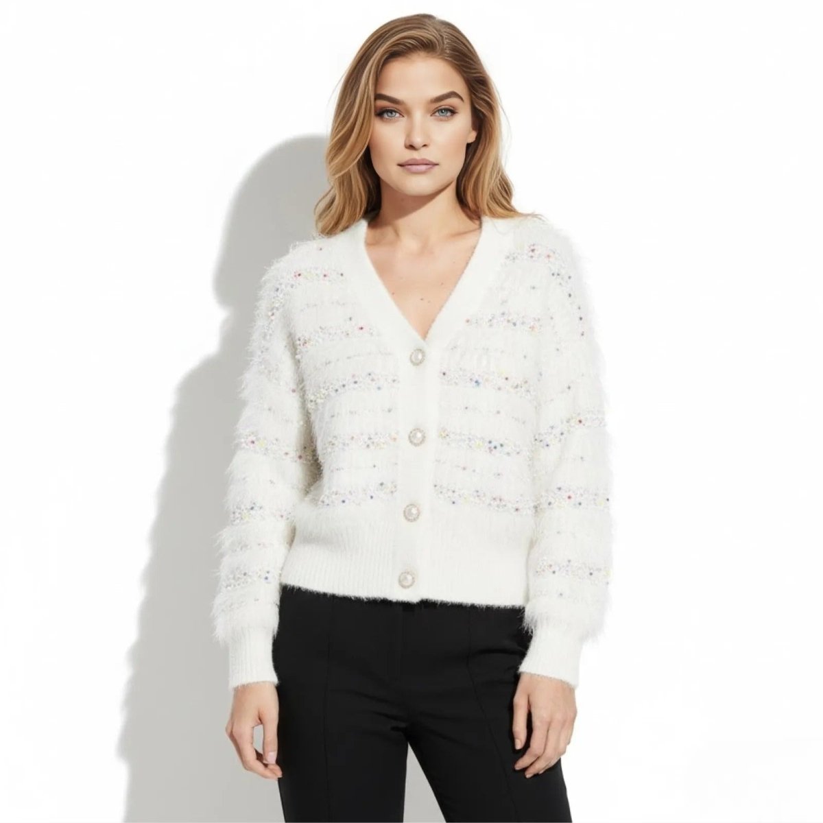 Model wearing the Kouvr white fuzzy confetti knit cardigan with pearl buttons, styled with black trousers.