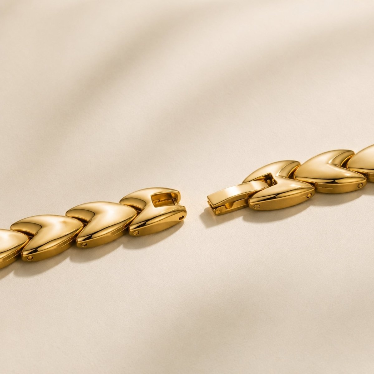 Close up macro shot of the adjustable fold over jewelry clasp on the Kouvr women's gold link watch bracelet