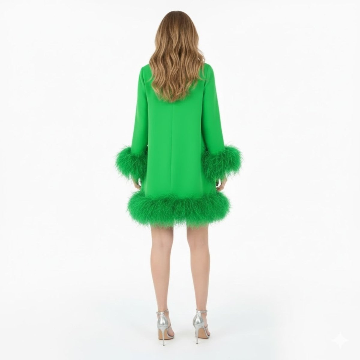 Back view of a model wearing the Kouvr green feather mini dress, showing the dress's structure and long sleeves.