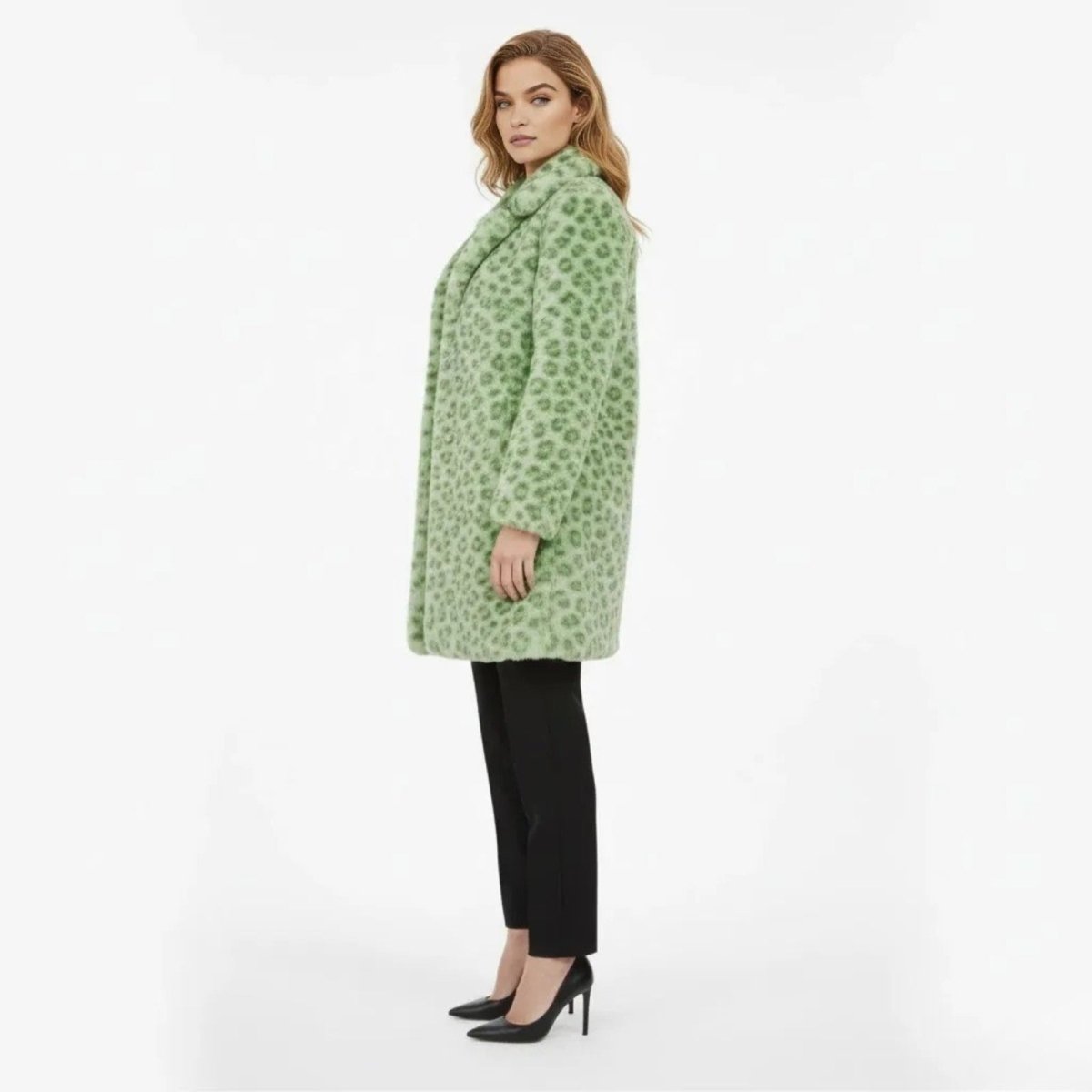 Model wearing the Kouvr green leopard print faux fur coat, shown from the side to display the relaxed fit and knee-length cut.