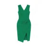 Woman wearing Kouvr's green V-neck ruched midi cocktail dress with a side slit