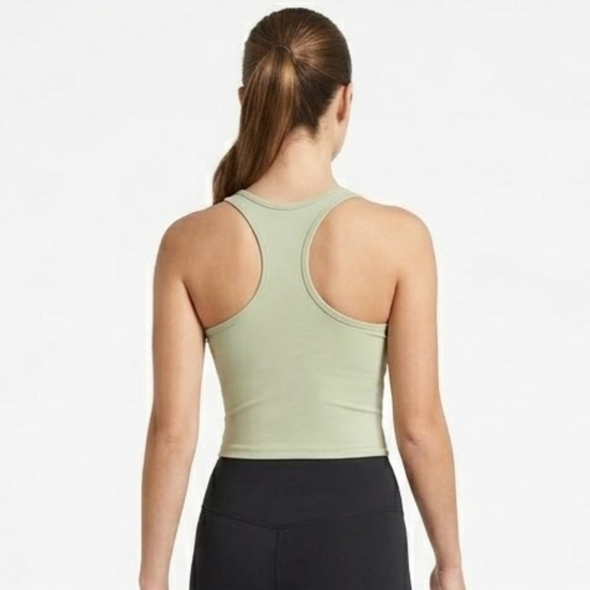 Back view of woman wearing Kouvr buttery soft green racerback athletic crop top showcasing supportive shoulder design.